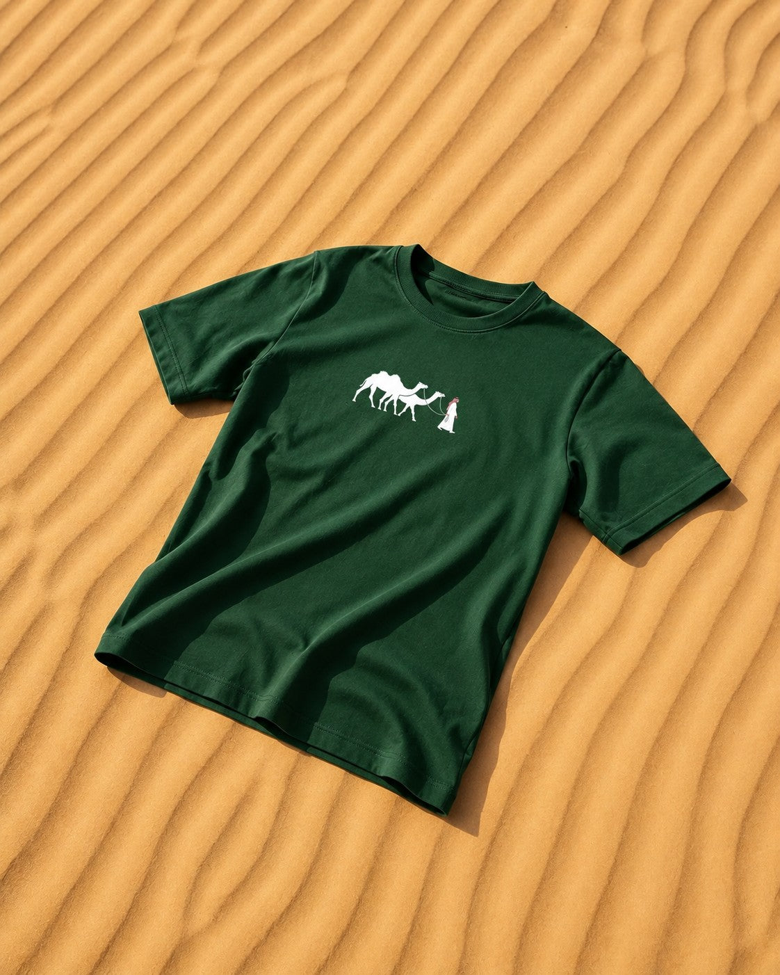 one5ive dark green oversized unisex cotton t-shirt with a small white camel graphic on a desert sand background